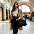 Elegant woman traveler in black and gold outfit at luxury airport with panther duffle bag