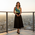 Hispanic woman in teal crane tank top black midi skirt heels rooftop golden hour